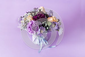 A spring gentle bouquet of mixed flowers on a purple background. First meeting bouquet or 8 of march concept