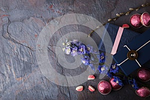 Spring gift with candy and flowers on a blue stone background