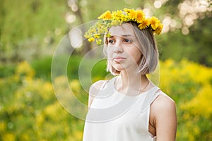 Spring girl in dandelion flowers crown outdoors