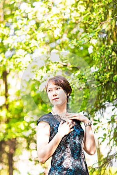 Spring girl portrait. Asian woman smiling happy on sunny summer or spring day outside in flowering tree garden. Pretty