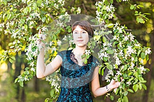 Spring girl portrait. Asian woman smiling happy on sunny summer or spring day outside in flowering tree garden. Pretty