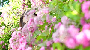 Spring girl. Woman in flower park, rose garden. Nature beauty.