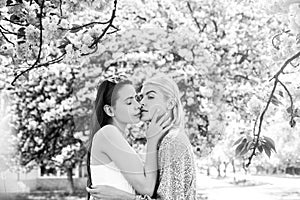 Spring girls. Lesbian couple kissing. Beautiful spring sexy girl with sakura flowers. Sensual kiss. Girlfriends love.