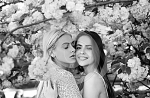 Spring girls. Lesbian couple kissing. Beautiful spring sexy young woman with sakura flowers. Sensual kiss. Lgbt.