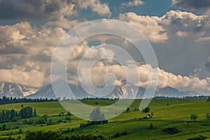 Spring green mountain landscape with meadows and rocky peaks. photo