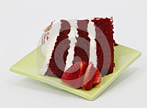 Spring green plate holds three layer red velvet cake slice