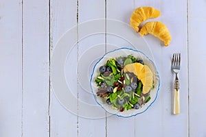 Spring green salad with blueberry, cranberry, almond and croissant