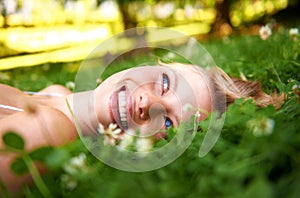 Spring, happy and calm with woman on grass in nature for relax, smile and peace. Park, flowers and field with face of
