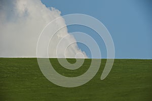 Rolling spring hills and on the background blue sky and clouds photo