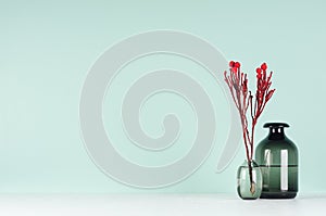 Spring home decor for library with red bizarre bouquet in black glass vases in soft light green mint menthe interior on white wood