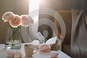 Spring home interior decor. Coffee cup, flowers, book. Decorated interior in living room. Blog, website or social media concept