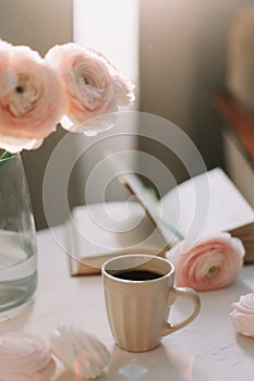 Spring home interior decor. Coffee cup, flowers, book. Decorated interior in living room. Blog, website or social media concept