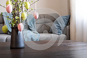 Spring home interior with Easter tree decorated colorful eggs. Self isolation
