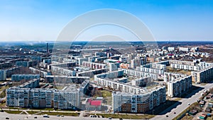 Spring landscape from a aerial view of the small city of Leninsk Kuznetsk, of the streets with a road, tall buildings, houses with