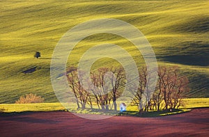 Spring landscape with amazing chapel in green fields at sunset
