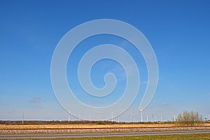 Spring landscape with blue skies and green, field and wind farm