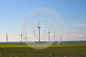 Spring landscape with blue skies and green, field and wind farm