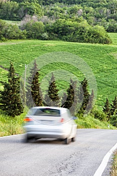 Spring landscape, car driving fast on country road