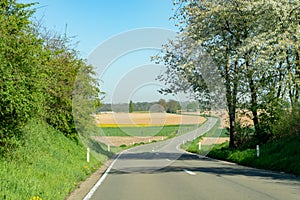 Spring landscape with fields, orchards and roads in Haspengouw region, Limburg, Belgium