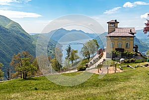 Spring landscape from Mount Bre, with view of lake Lugano, range of mountains and restaurant, Switzerland