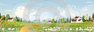 Spring landscape with peaceful rural nature in springtime with wild grass land,farm house,mountain,sun, blue sky and clouds