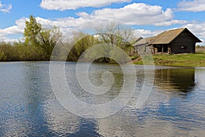 Spring landscape with pond and an old wooden structure