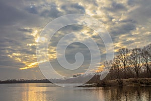 Spring landscape. sun shining through heavy clouds over the lake