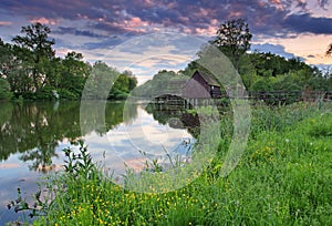 Spring landscape at sunset with watermill