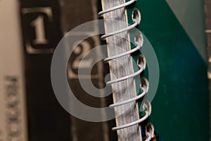 A spring-loaded notebook among old brown books