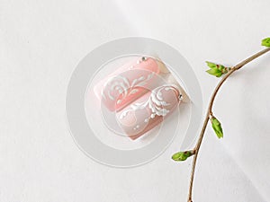 Spring manicure. Tips with pink monogram design on a white background.
