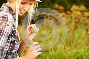 Spring, meadow and woman pick flower in field for freedom, wellness and fresh air outdoors. Nature, sunshine and happy