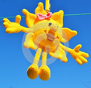 Spring mood, Bright yellow sun made of threads on a blue sky background