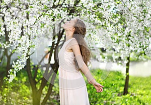 Spring mood, cute girl smell flowering tree