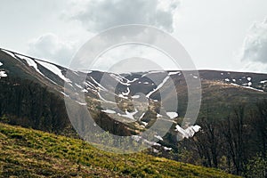 Spring in mountains. Beautiful mountain landscape with snow on the north slope photo