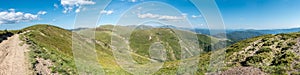 Spring mountains under blue sky with clouds - panoramic view