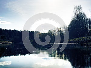 Spring narrow river among meadows and coppices