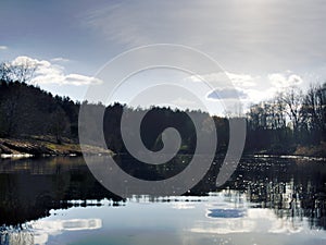 Spring narrow river among meadows and coppices