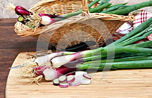 Spring onions, cebollitas cambray, on a cutting board being prep photo