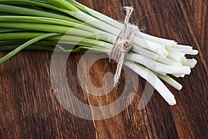 Spring onions on dark wood