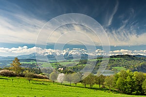 Spring panorama with green fields and trees in Malopolska region, Poland. Czorsztyn castle and snow covered Tatra Mountains