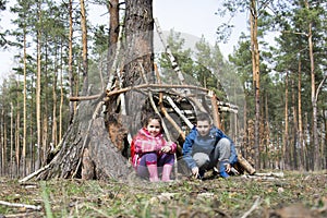 In the spring in a pine forest, a brother with a small sister bu