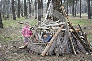 In the spring in a pine forest, a brother with a small sister bu