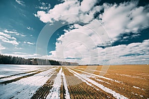 Spring Plowed Field Partly Covered Winter Melting Snow Ready For New Season. Ploughed Field In Early Spring. Farm