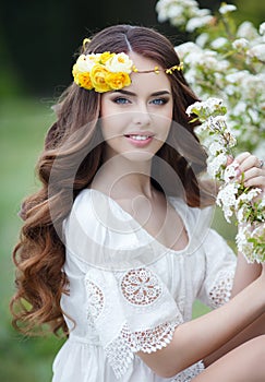 Spring portrait of a beautiful woman in a wreath of flowers