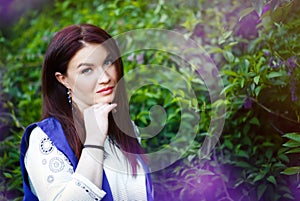 Spring portrait of serious beautiful caucasian 30 years old woman with fashionable makeup in purple lilac. Allergy time spring.