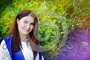 Spring portrait of serious beautiful caucasian brunette 30 years old woman with fashionable makeup in purple lilac. Make-up for