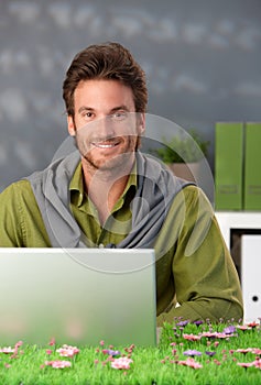Spring portrait of smiling man with computer