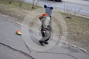 Spring in a provincial town, the baby walks and rolls a typewriter on a string