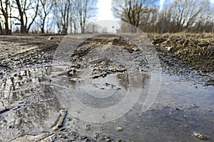 Spring, a puddle on a dirt road. Concept. Seasonal off-road