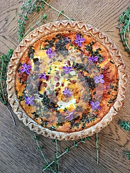 Spring quiche with fresh herbs decorated with flowers